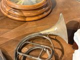 une table en bois sur laquelle se trouvent une horloge, un cor et une autre horloge