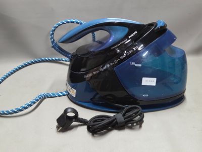 un fer à repasser à vapeur bleu et noir posé sur une table blanche