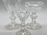 trois verres à pied en verre transparent posés les uns à côté des autres sur une table