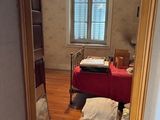 a room with a bed and a table with a red table cloth on it