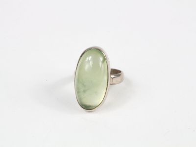 une bague sertie d'une pierre verte sur un fond blanc