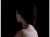 une femme debout devant un fond noir