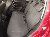 the back seats of a red car with a black seat belt