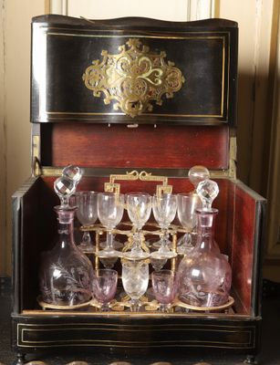 une mallette noire et dorée contenant de nombreux verres à vin