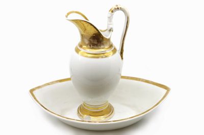 a white and gold saucer with a gold handle
