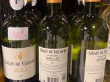 plusieurs bouteilles de vin sont alignées sur une étagère