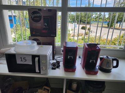 a table with a microwave, coffee maker, and other items on it