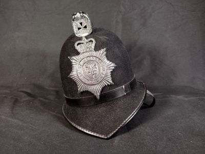 une casquette de policier ornée d'un insigne, sur fond noir