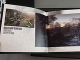 a person holding a book with a picture of a city in it