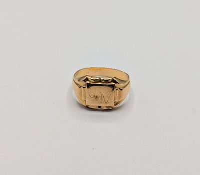 gros plan d'une bague en or sur une surface blanche