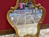 un miroir posé par terre devant un mur rouge