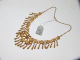 gros plan sur un collier en or portant une étiquette