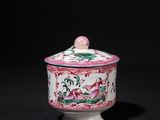 a pink and white bowl with a lid on a black surface