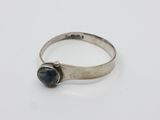 un gros plan d'une bague en argent sertie d'une pierre noire
