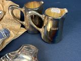 a silver plate and a silver cup and saucer on a blue background