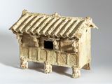un petit bâtiment en argile posé sur une surface blanche