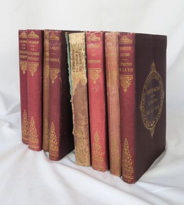 trois livres sont alignés sur une surface blanche