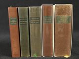 trois vieux livres sont alignés sur une surface noire