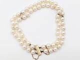 un bracelet de perles blanches avec un fermoir en or