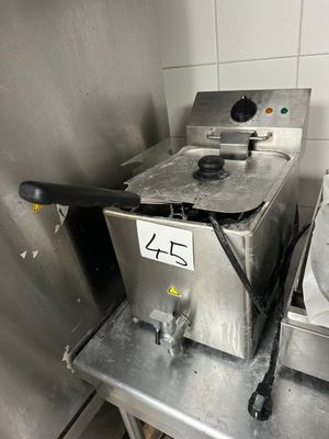 stainless steel counter top with a fryer and a sink in a kitchen