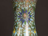 a vase with a floral design on it sitting on a table
