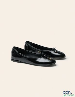 Les chaussures noires de la femme sont alignées sur une surface blanche