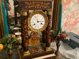 a clock that is sitting on a table in front of a mirror