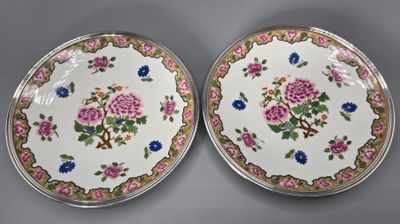 deux assiettes ornées de fleurs et de feuilles, posées sur une table