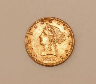 a close up of a gold coin with a woman ' s head on it