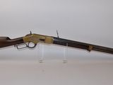 a rifle with a wooden barrel on a clear stand
