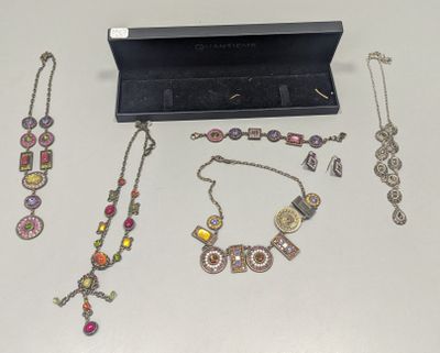 de nombreux bijoux posés sur une table à côté d'une boîte noire
