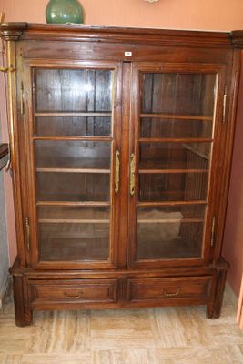 un meuble en bois avec des portes en verre dans le coin d'une pièce
