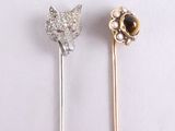 two pins with a cat head on them sitting next to each other