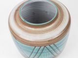 a blue and brown vase on a white surface