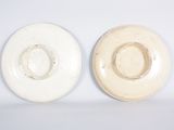 two white plates sitting next to each other on a table
