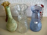 trois vases en verre posés sur une table l'un à côté de l'autre