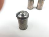 a small silver object sitting on a table next to a cup