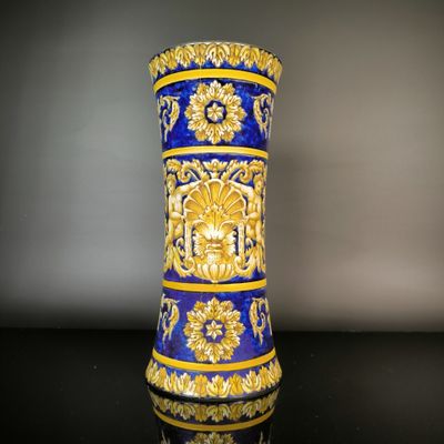 un vase bleu et or posé sur une table noire