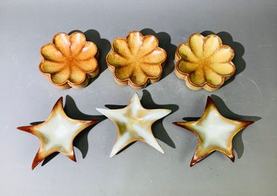 Plusieurs pièces de poterie sont disposées en rangée sur une table