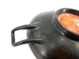 a pot of soup sitting on a table with a spoon in it