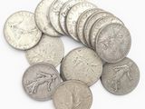 une pile de pièces d'argent posée sur une surface blanche