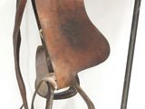 a horse saddle hanging on a metal stand