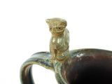 a brown and blue vase with a monkey on the handle