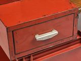 a red cabinet with a drawer on top of it