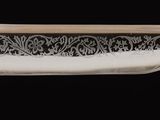 a close up of a silver object on a black background