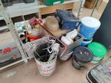 several buckets of paint are sitting on a shelf in a room