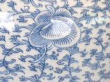 a blue and white vase with a flower design on it