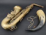 a saxophone and a horn on a black surface
