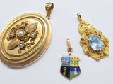 two gold pendants and a pendant with a picture of an eagle on it