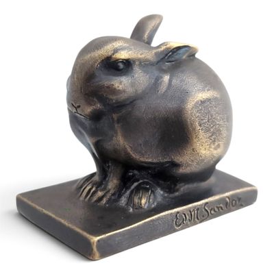 a bronze sculpture of a rabbit sitting on a base